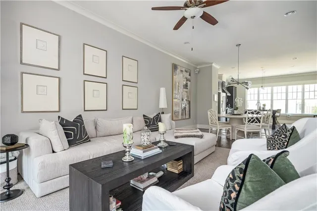 a living room with furniture kitchen view and a chandelier