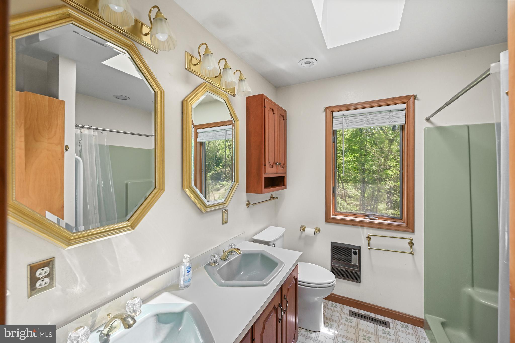 1680 East Street Road Kennett Square, PA 19348 - Photo 17 of 30 a bathroom with a sink a mirror a toilet and a window
