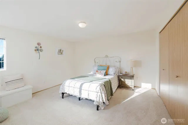 a bedroom with a bed and a lamp on the dresser