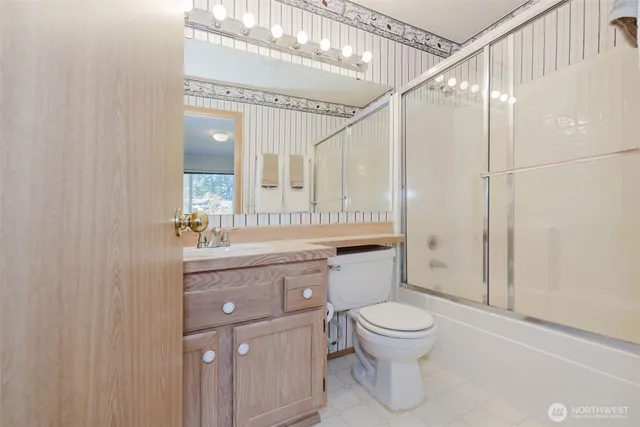 a bathroom with a toilet a sink and a large mirror