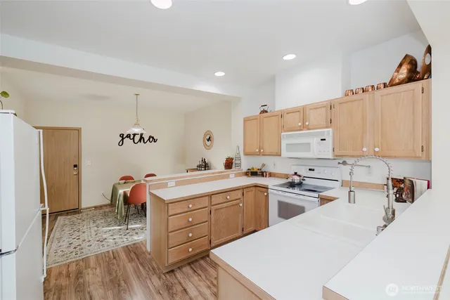 a kitchen that has a lot of cabinets in it and wooden floors