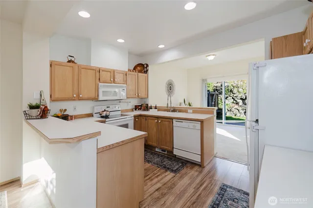 a kitchen with a sink a stove a refrigerator and white cabinets