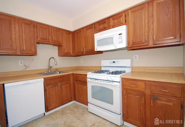 a kitchen with cabinets appliances a sink and a counter top space