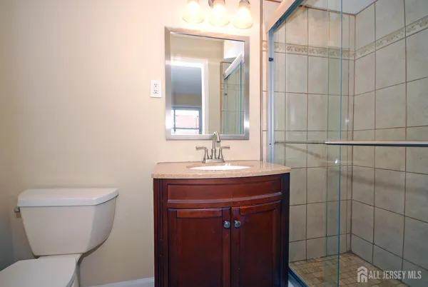 a bathroom with a toilet a sink and mirror