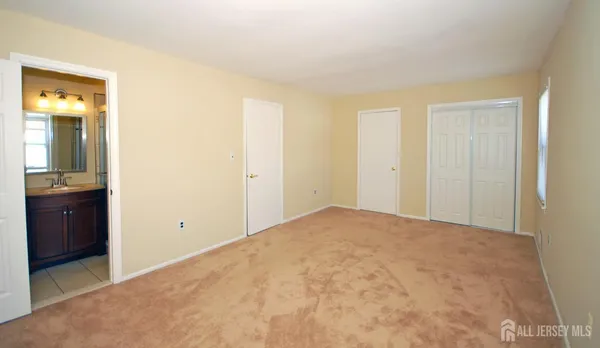 an empty room with closet and mirror