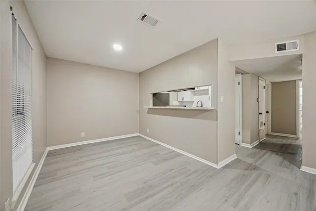 wooden floor in an empty room with a kitchen
