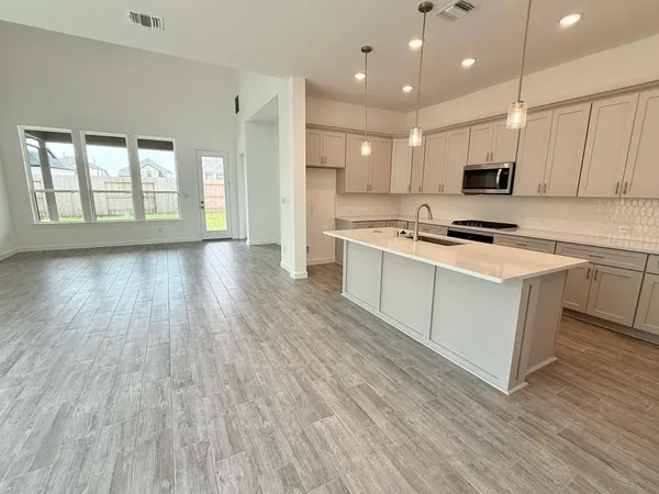 a kitchen with kitchen island a stove a sink a center island and cabinets