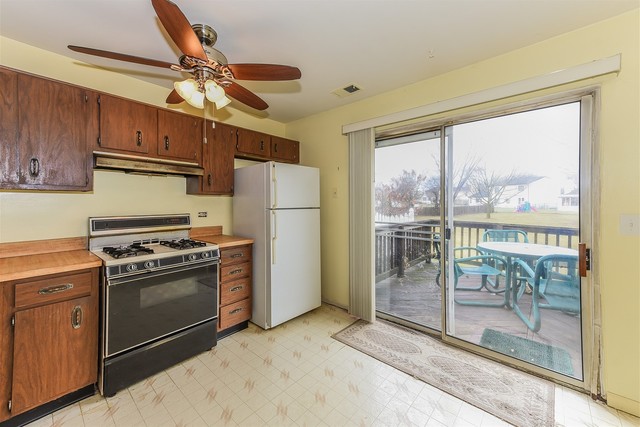 386 Rodenburg Road Roselle, IL 60172 - Photo 8 of 21 a kitchen with a stove a refrigerator and a view of living room