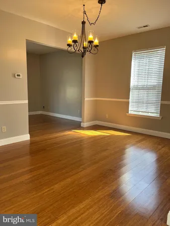 a view of a livingroom with wooden floor and a chandelier