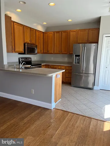 a kitchen with stainless steel appliances granite countertop a refrigerator a stove a sink and a microwave