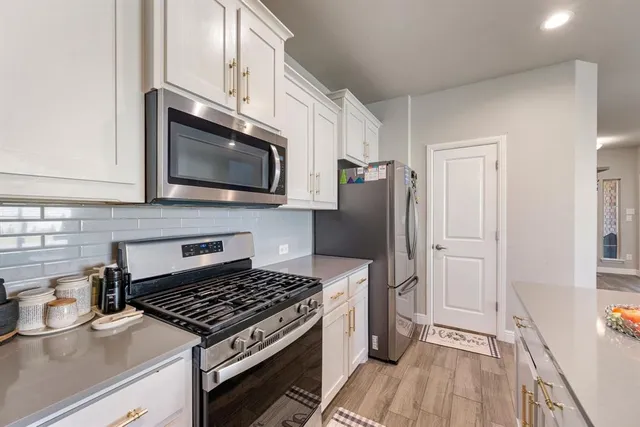 a kitchen with granite countertop a stove and a wooden floor