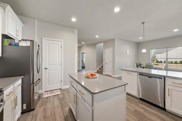 a kitchen with stainless steel appliances granite countertop refrigerator sink and wooden floor