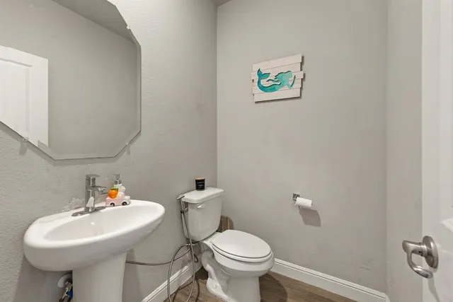 a bathroom with a sink a toilet and a mirror