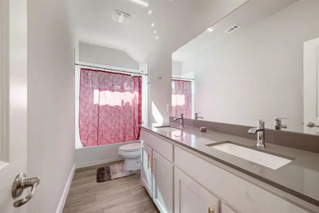 a bathroom with a granite countertop sink a large mirror and a bathtub
