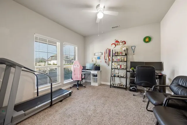 a view of a bedroom with workspace and windows