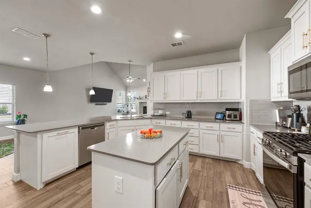 a kitchen with stainless steel appliances granite countertop a sink and a stove top oven