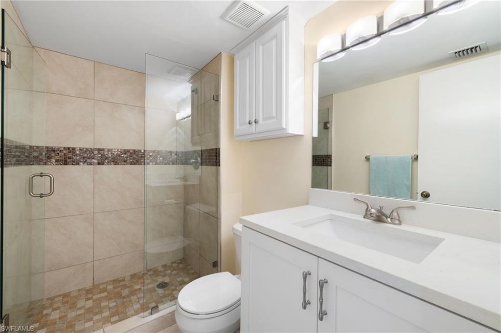 5 High Point Circle West, Unit 307 Naples, FL 34103 - Photo 11 of 31 a bathroom with a sink a toilet and shower