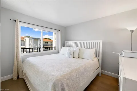 a large bed sitting in a bedroom next to a window