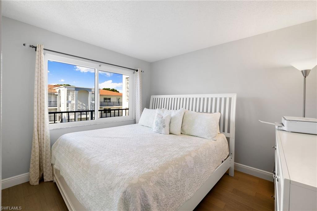 5 High Point Circle West, Unit 307 Naples, FL 34103 - Photo 12 of 31 a large bed sitting in a bedroom next to a window