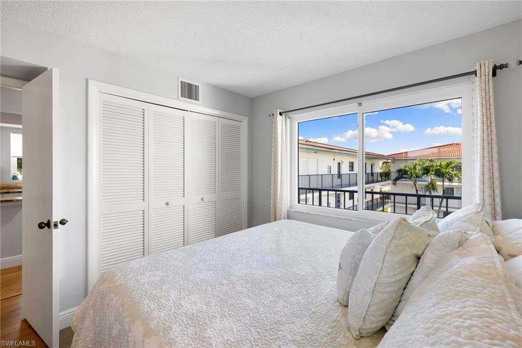5 High Point Circle West, Unit 307 Naples, FL 34103 - Photo 13 of 31 a bedroom with a large bed and a large window