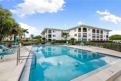 a view of a house with pool and chairs