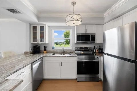 a kitchen with stainless steel appliances granite countertop a stove a refrigerator and a sink
