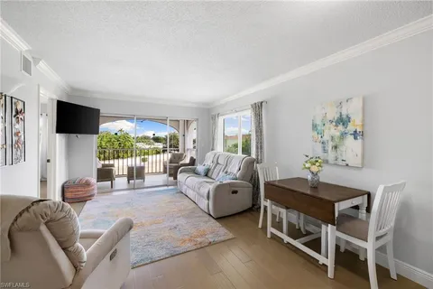 a living room with furniture a flat screen tv and a large window