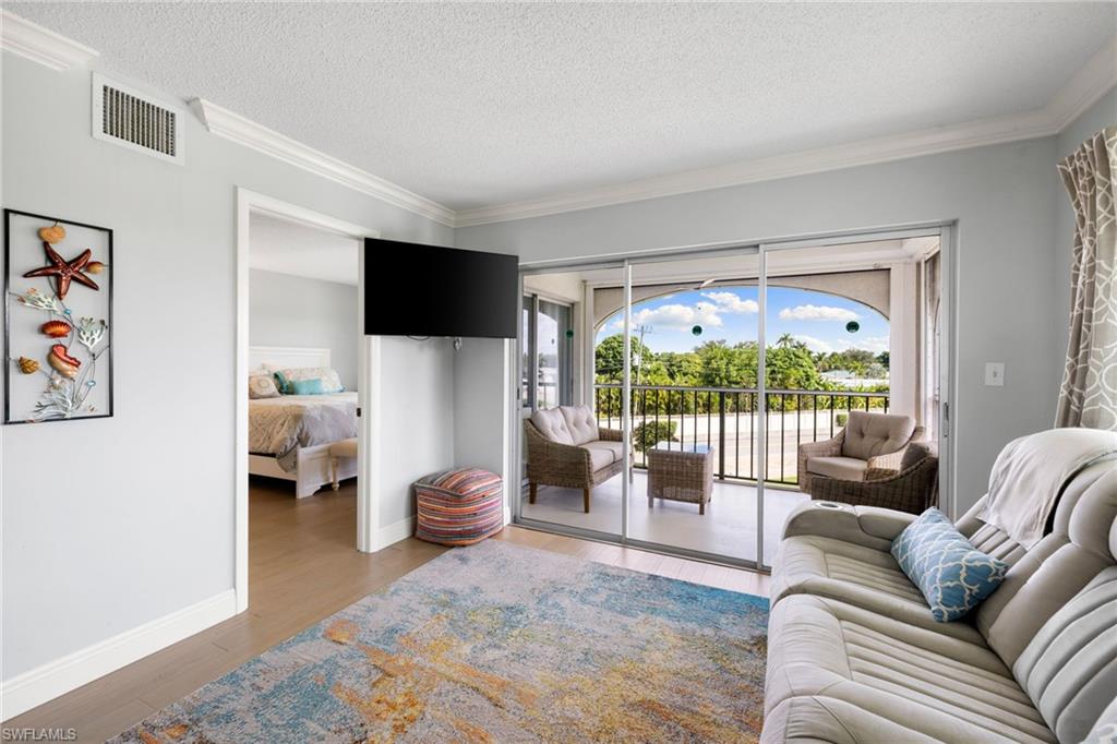 5 High Point Circle West, Unit 307 Naples, FL 34103 - Photo 9 of 31 a living room with furniture and a flat screen tv
