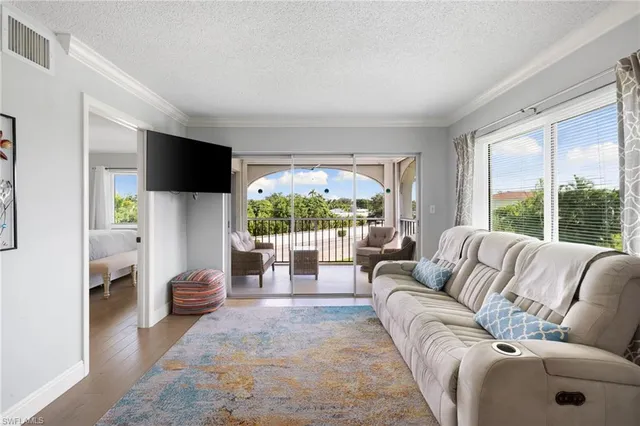 a living room with furniture a flat screen tv and a large window