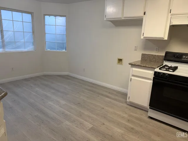 a view of a kitchen with wooden floor and electronic appliances