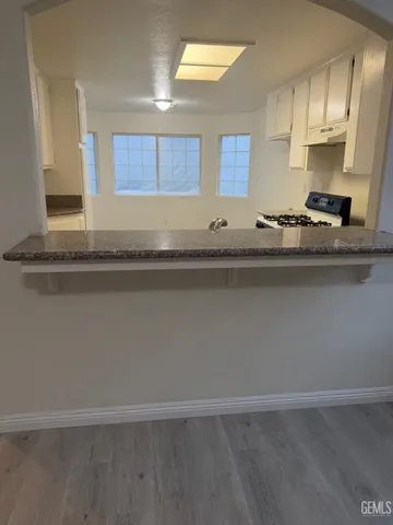 a kitchen with granite countertop a sink and cabinets