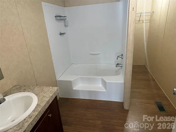 a backyard of a house with large trees and wooden fence