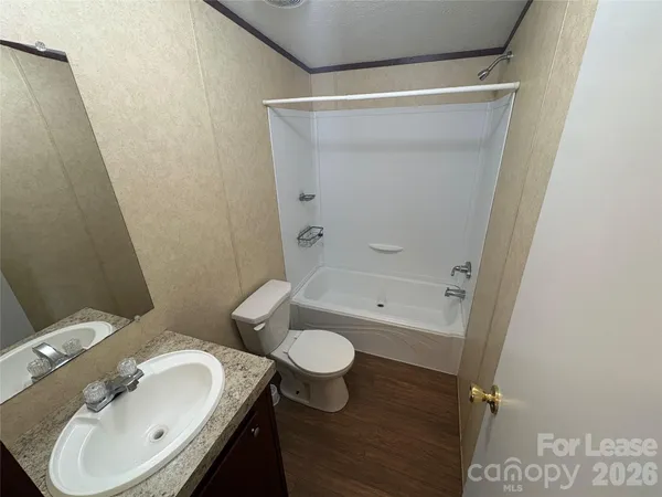 a bathroom with a granite countertop sink toilet and a mirror