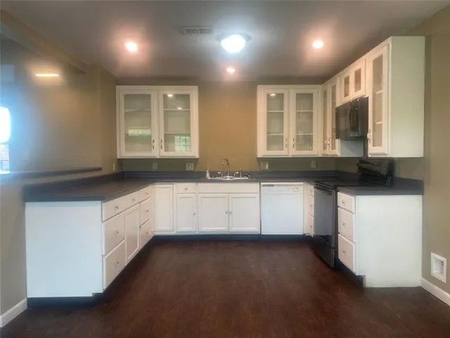 a white kitchen with granite countertop white cabinets and sink