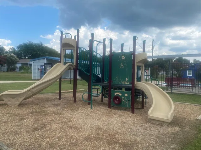 a view of a swimming pool with a bench and trees in the background