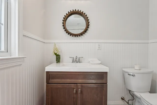 a bathroom with a sink a toilet and a mirror