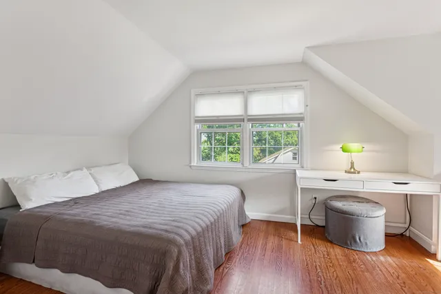 a bedroom with a bed a table and window