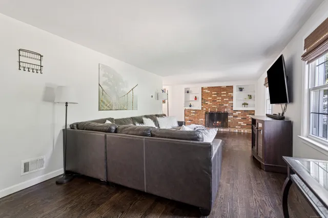 a living room with furniture a flat screen tv and wooden floor