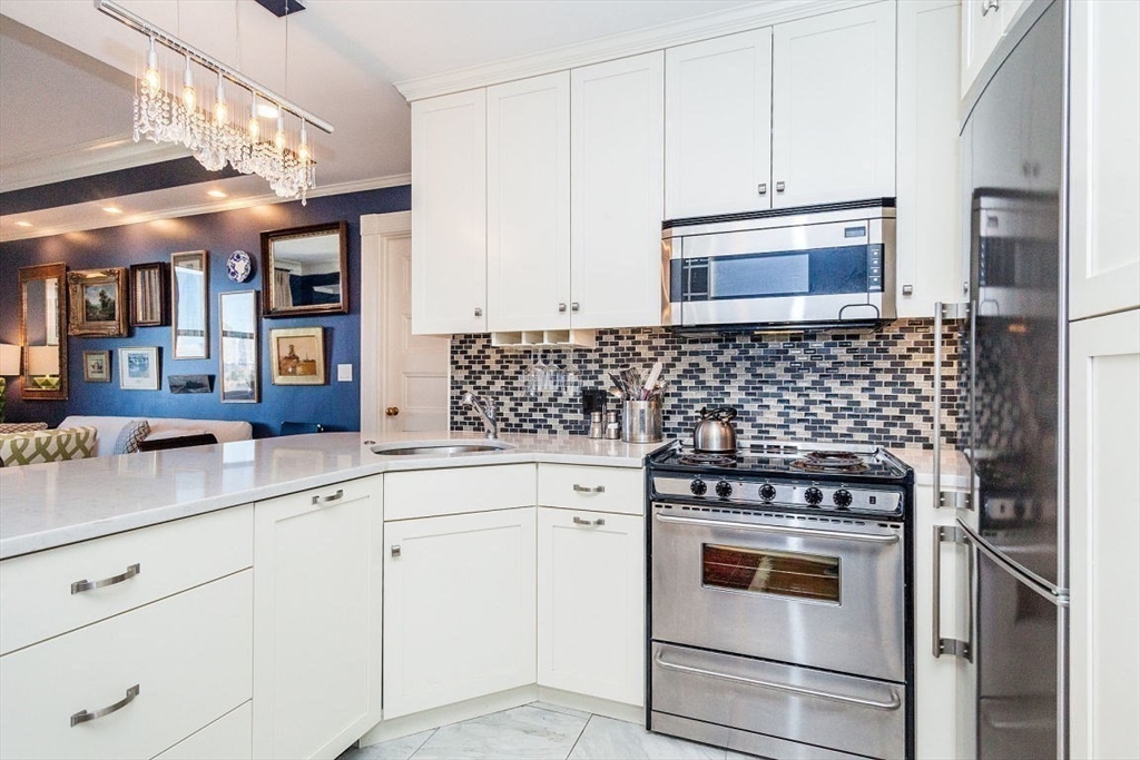 21 Beacon Street, Unit 5I Boston, MA 02108 - Photo 3 of 13 a kitchen with white cabinets and white appliances