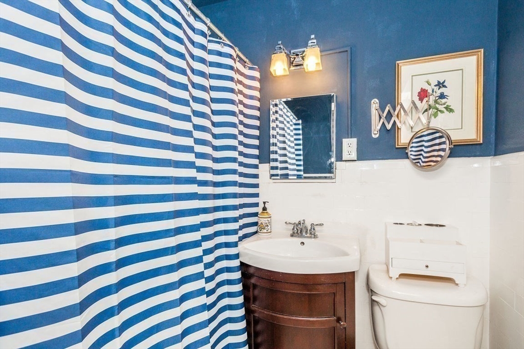 21 Beacon Street, Unit 5I Boston, MA 02108 - Photo 6 of 13 a bathroom with a sink a toilet and a mirror