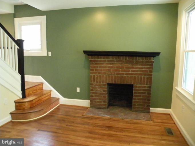 629 Deepdene Road Baltimore, MD 21210 - Photo 7 of 13 a view of a livingroom with wooden floor and a fireplace