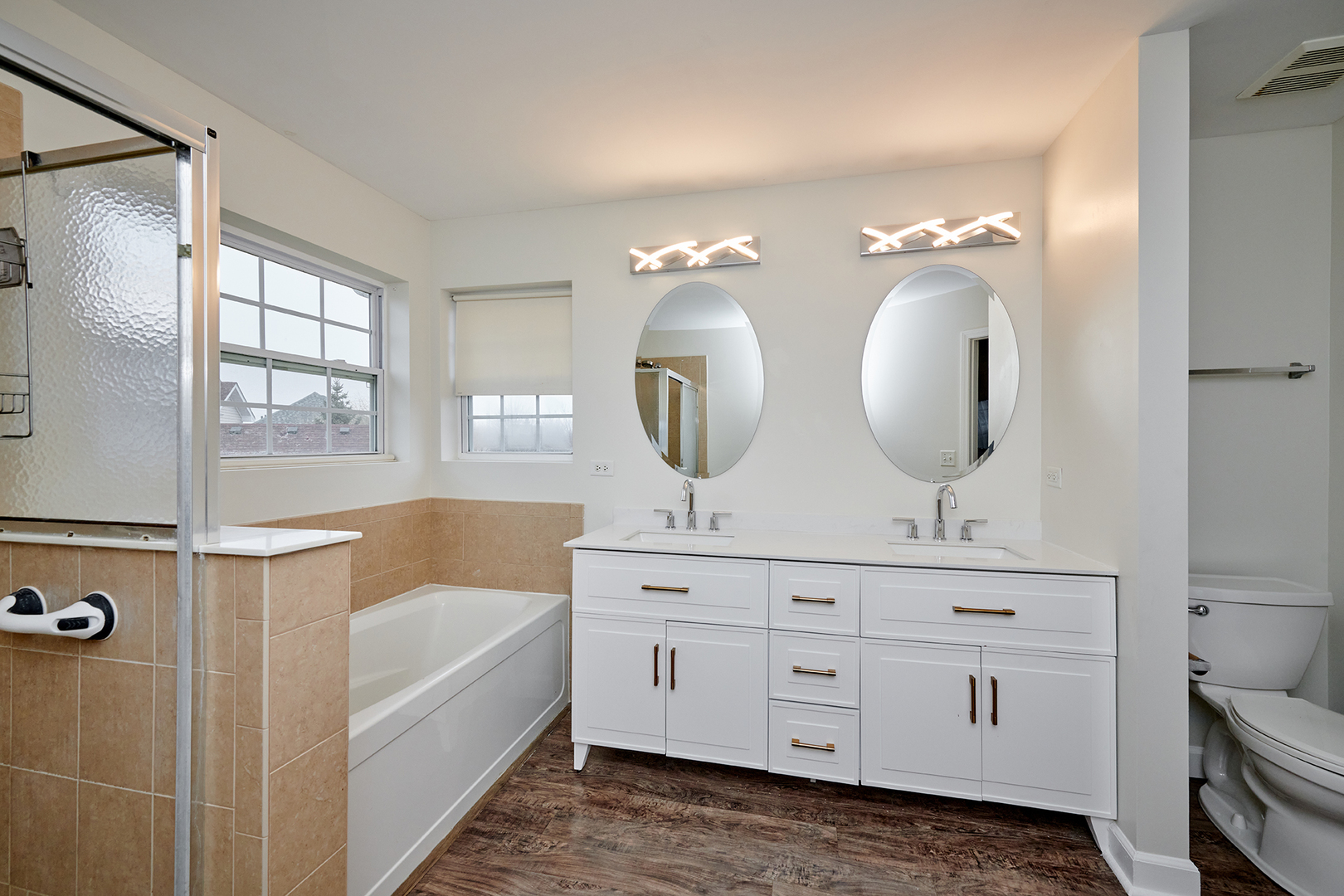 540 Wynbrooke Road Romeoville, IL 60446 - Photo 14 of 27 a bathroom with a double vanity sink a mirror a lamp and bathtub