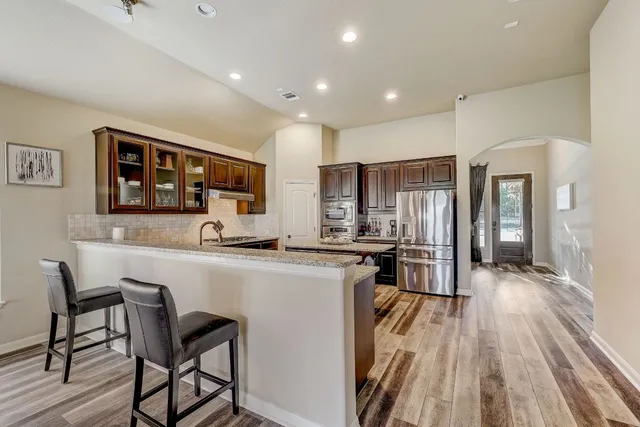 a kitchen with stainless steel appliances a refrigerator a stove a sink dishwasher and a oven with wooden floor