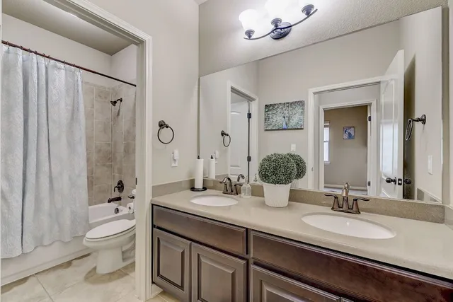 a bathroom with a double vanity sink toilet and shower