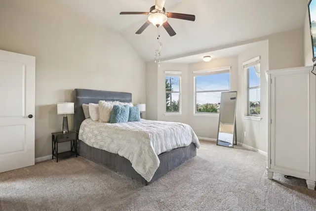 a spacious bedroom with a bed and a chandelier