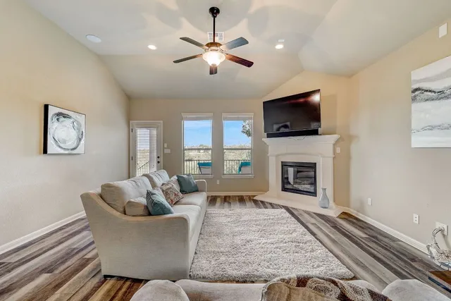 a living room with furniture a fireplace and a flat screen tv