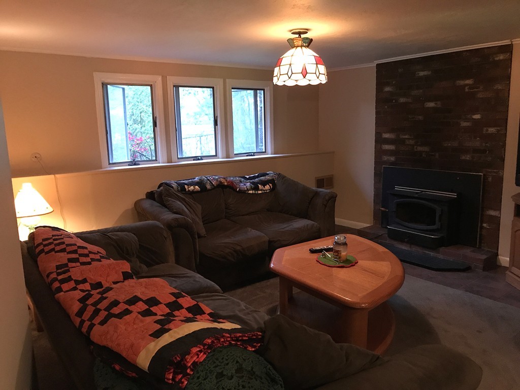 39 Old Bolton Road Hudson, MA 01749 - Photo 19 of 19 a living room with furniture a fireplace and a chandelier