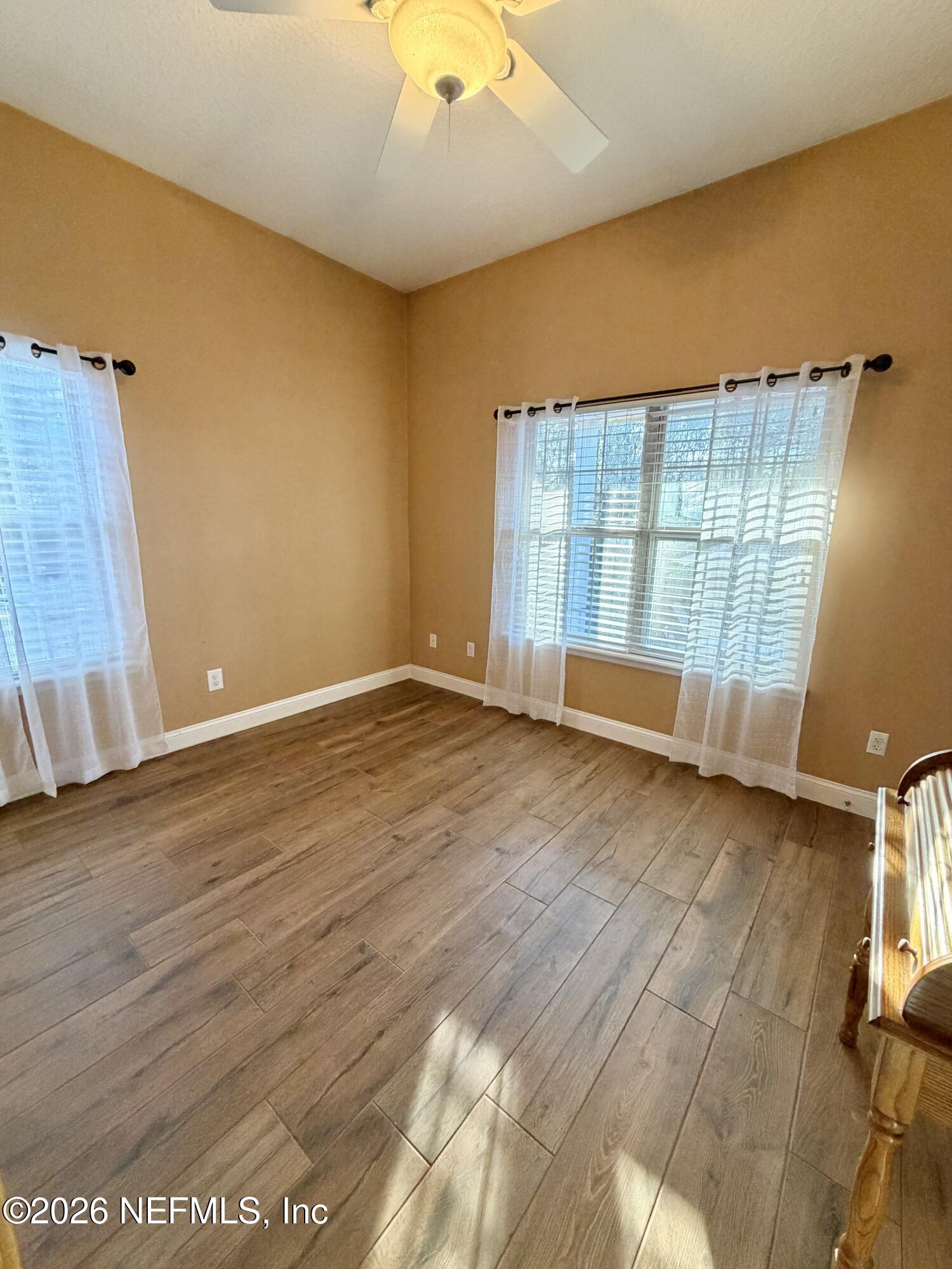 6116 Copper Drive Macclenny, FL 32063 - Photo 19 of 21 an empty room with wooden floor and windows