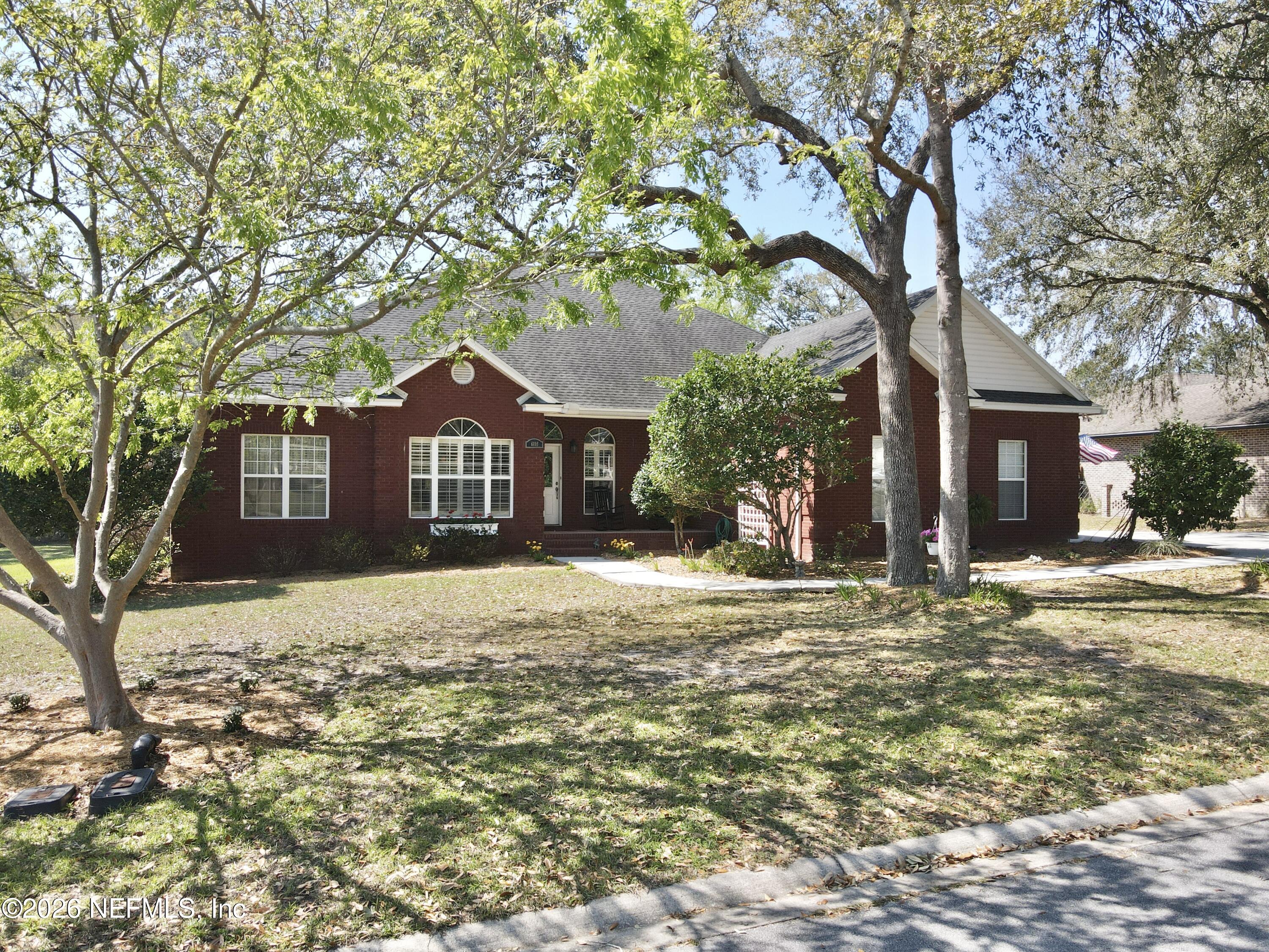 6116 Copper Drive Macclenny, FL 32063 - Photo 2 of 21 a front view of a house with a yard and garage