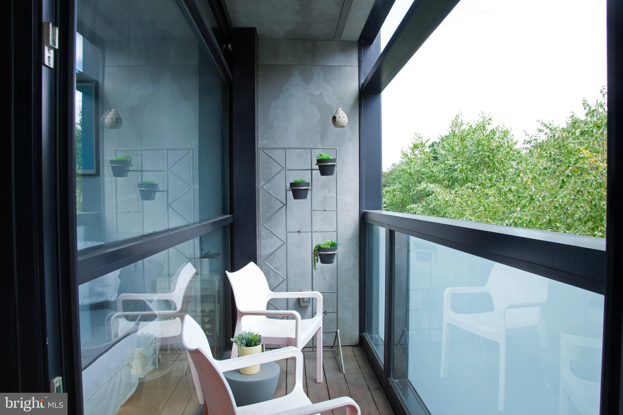 2250 11th Street Northwest, Unit 304 Washington, DC 20001 - Photo 10 of 17 a view of balcony with chair and potted plant